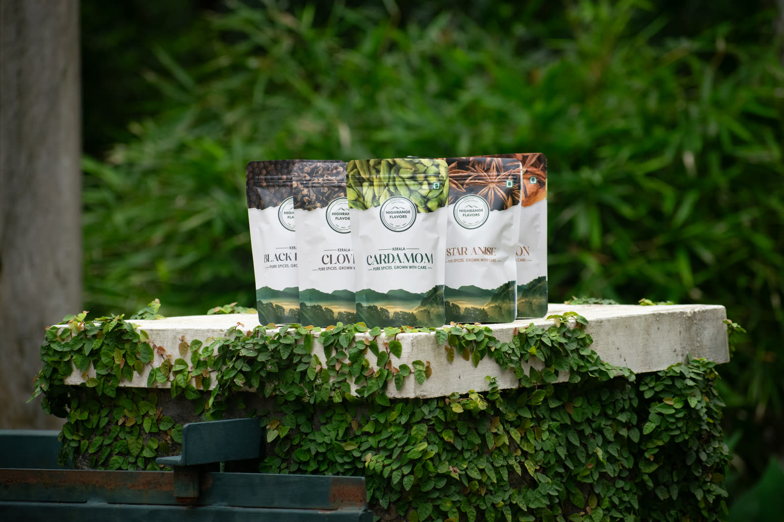 High Range wholesale spice packs lined up on a mossy estate wall