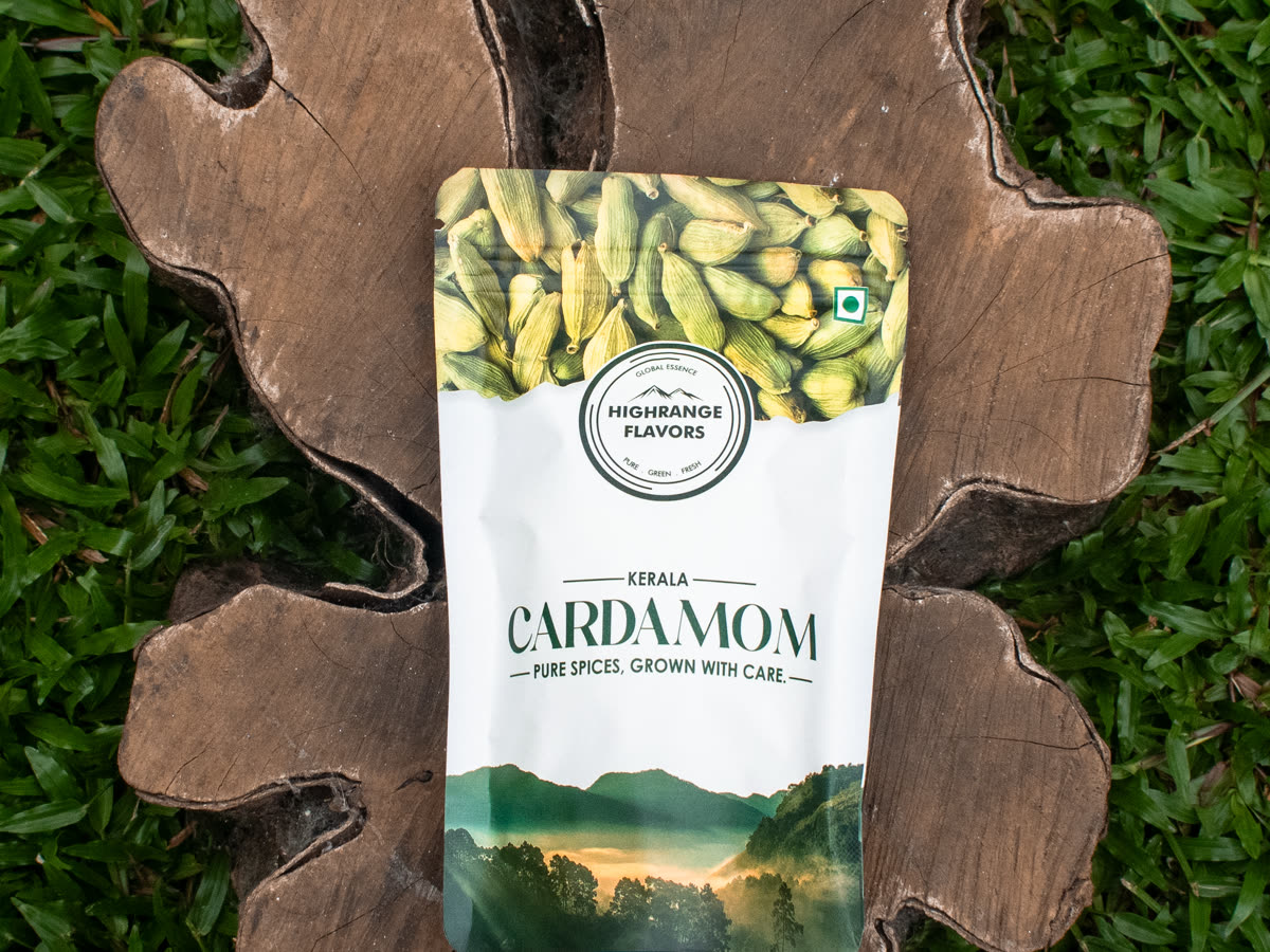 A packed retail pouch of estate cardamom on a wooden board